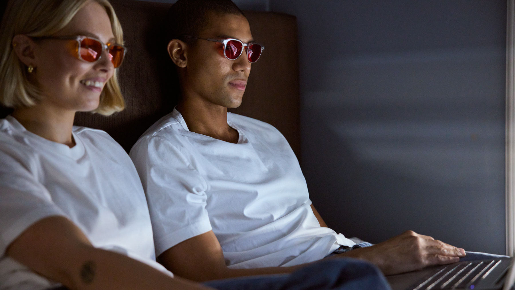 Man and woman wearing their Filter Optix blue light blocking glasses while watching series at night, to get better sleep