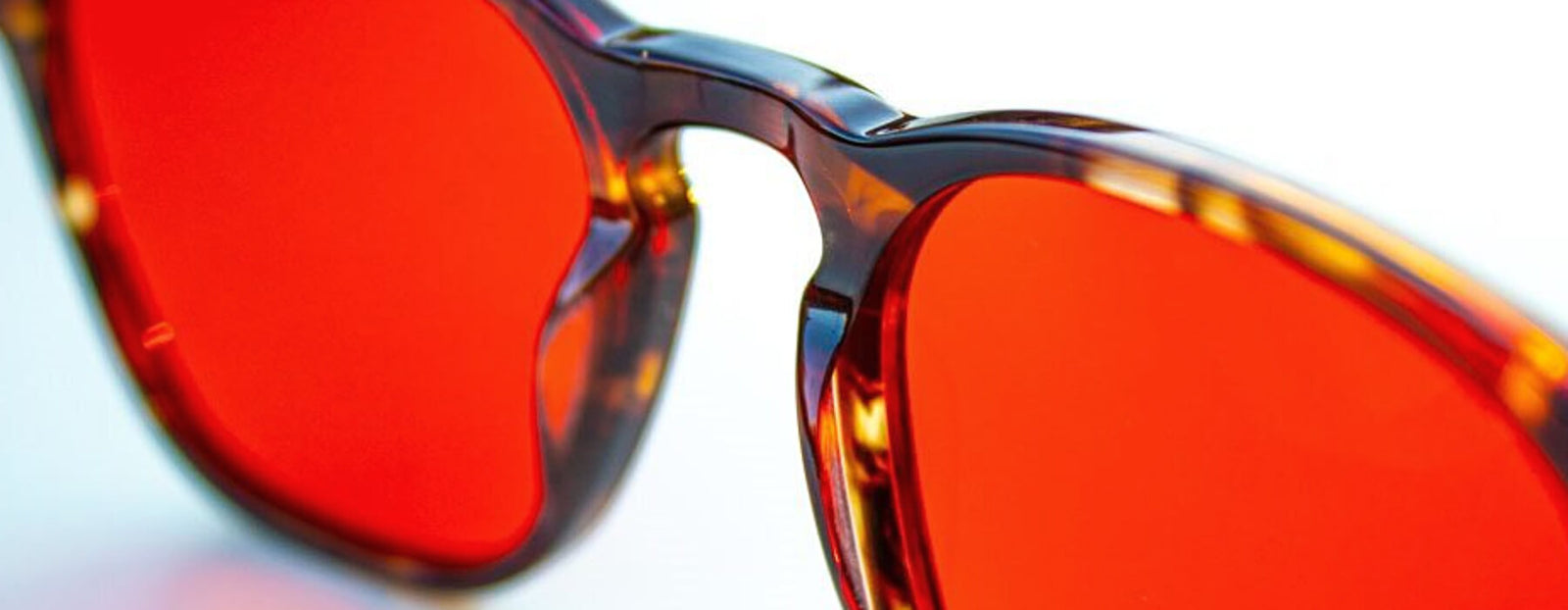 Close-up of red blue light blocking glasses showing lens detail and frame quality